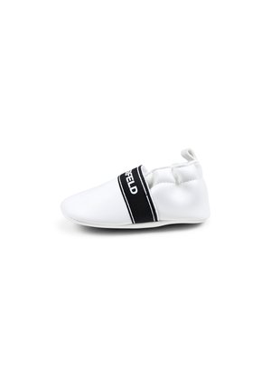 Scarpa bianca slip-on realizzata in materiale liscio, con un elastico nero sulla parte superiore che presenta del testo. Punta arrotondata e suola morbida e flessibile.