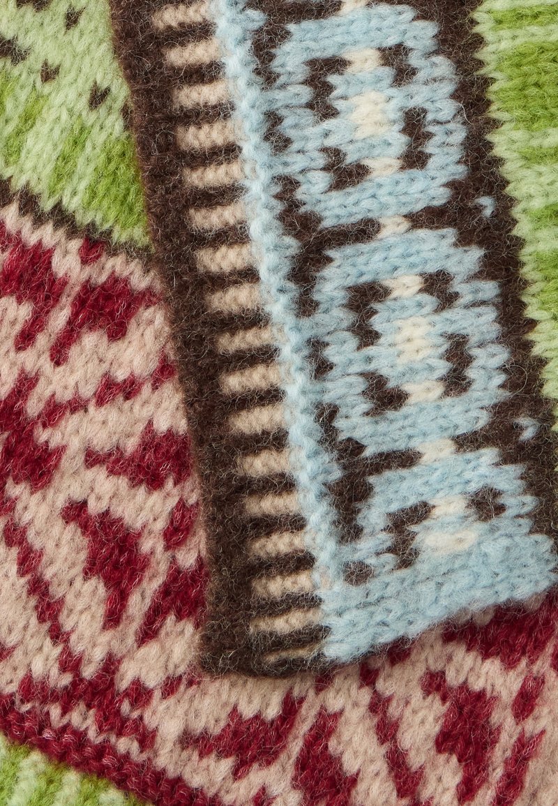 Wool textile featuring a blend of colors: green, red, brown, and light blue. Intricate patterns with geometric and floral designs.