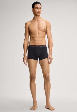 Black boxer briefs with a patterned elastic waistband. Made from a smooth fabric, they feature a snug fit and mid-thigh length.