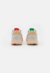 Sneakers con tomaia in pelle beige, forma arrotondata, linguette per il tallone in rosso e verde a contrasto, e suola in gomma texturizzata e dalle tonalità spente.