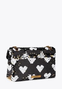 Borsetta in paillettes bianca e nera con motivi a cuore, dettagli in oro e tracolla a catena. Forma oblunga con chiusura a patta.