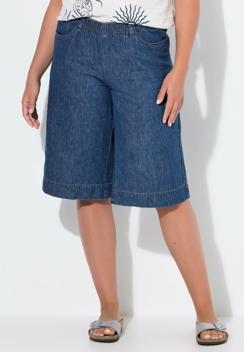 Culottes de denim con una cómoda cinturilla elástica, de longitud hasta la rodilla, en un tono azul oscuro, con dos bolsillos frontales y un dobladillo ancho.