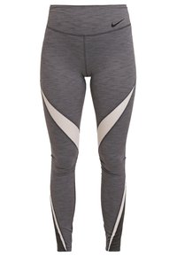 Szare legginsy z teksturowanej tkaniny, z kontrastowymi kremowymi akcentami i kanciastymi wzorami po bokach. Czarne logo Nike na talii.
