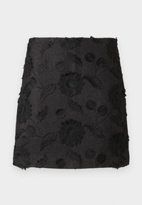 Svart linnekjol med broderade blommönster i varierande texturer, med en figurnära passform och en något fransad fåll.
