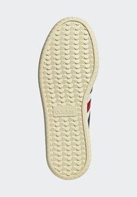 Gummisula med ett texturerat greppmönster. Har det präglade "adidas"-logot och randig design med röda, vita och blå accenter.