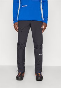 Čierne outdoorové nohavice s vreckom na zips, textúrovaná tkanina, zosilnené kolená, s logom "MAMMUT" na dolnej časti nohy.