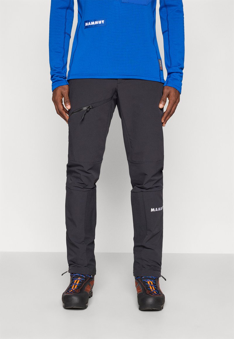 Čierne outdoorové nohavice s vreckom na zips, textúrovaná tkanina, zosilnené kolená, s logom "MAMMUT" na dolnej časti nohy.
