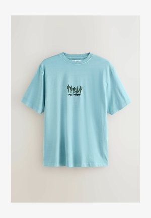 Világoskék rövid ujjú pamut póló zöld kaktusz hímzéssel és a "TERRY-URBAN" felirattal a minta alatt.