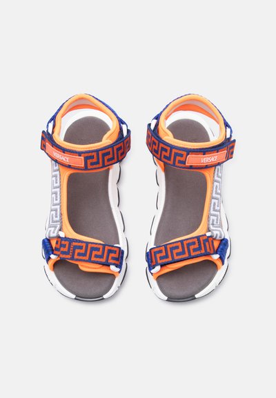 Αθλητικά σανδάλια παιδικά με πορτοκαλί και μπλε ρυθμιζόμενα λουριά που φέρουν σχέδιο ελληνικού κλειδιού και το λογότυπο "Versace" στα λουριά του αστραγάλου.