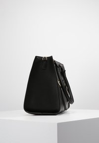 Czarna syntetyczna torebka o kształcie trójkąta, z górnym uchwytem i złotymi akcentami. Gładka tekstura, elegancki design.