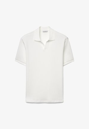 Polo bianca a maniche corte con trama a coste e un colletto corto aperto, mostrata distesa su uno sfondo bianco.