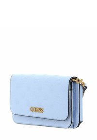 Sac bandoulière en similicuir bleu clair avec motif embossé, logo "GUESS" doré, bandoulière en chaîne et accents noirs. Design rectangulaire compact.