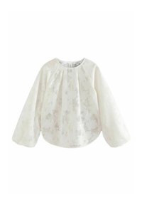 Blouse blanche à manches longues bouffantes, ornée d'un motif de dentelle florale. Tissu doux et léger avec un col rond et une coupe décontractée.