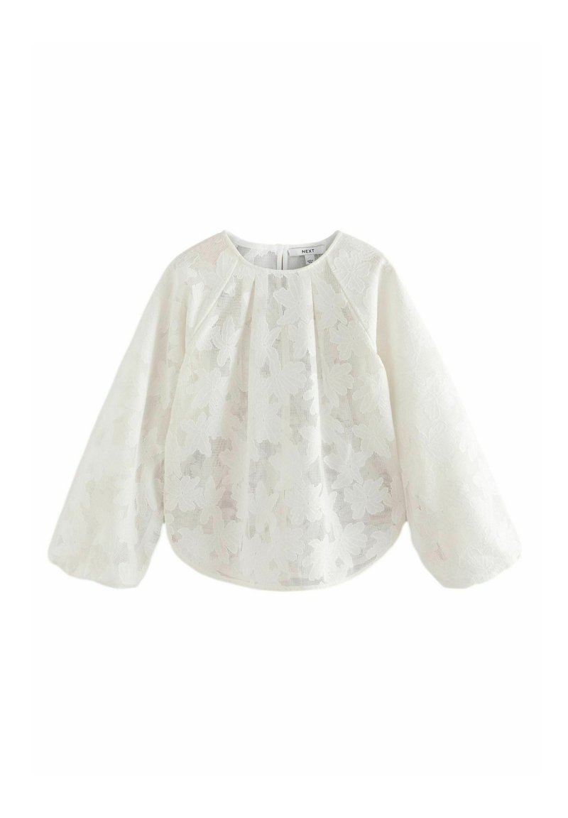 Blouse blanche à manches longues bouffantes, ornée d'un motif de dentelle florale. Tissu doux et léger avec un col rond et une coupe décontractée.