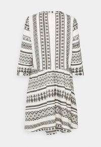 Vestido de estampado en blanco y negro que presenta diseños geométricos, un corte holgado y mangas hasta los codos. El material parece ligero y texturizado.