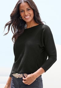 Schwarzer strukturierter Strickpullover mit weitem Rundhalsausschnitt, 3/4-Ärmeln und lockerer Passform, kombiniert mit einem leichten geflochtenen Gürtel.