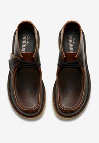 Scarpe in pelle marrone con finitura liscia, caratterizzate da accenti marroni scuri a contrasto, punta tonda e design senza lacci.