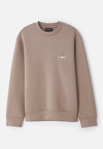 Sweatshirt marron en matériau doux. Doté d'un col rond et de poignets côtelés. Logo décoratif "EVA" sur la poitrine avec un emblème au-dessus.