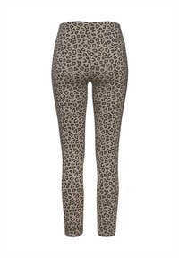 Leggings de estampado de leopardo en una tela elástica. Fondo beige con manchas negras, diseño ajustado, corte de longitud completa y cintura alta.