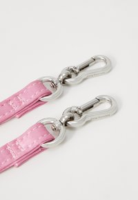Sangle en satin rose avec des fermoirs en métal argenté, présentant un design cousu et des connecteurs en anneau circulaire à chaque extrémité.