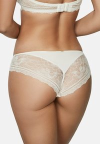 Culottes en dentelle et coton couleur ivoire, présentant des panneaux en dentelle florale sur les côtés, des bordures festonnées et un design lisse et minimaliste.