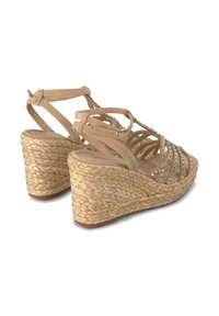 Sandali con zeppa con cinturini in suede beige, caratterizzati da un tacco in juta intrecciata e strass decorativi lungo la parte superiore per un tocco in più.