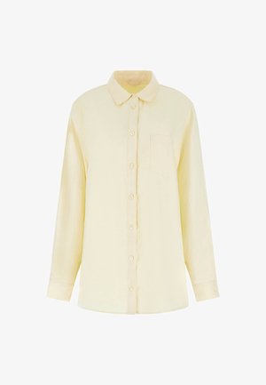 Sárga, hosszú ujjú, gombos ing, könnyű anyagból készült. Hátán gallér és egyetlen mellzseb található. Sima textúra.