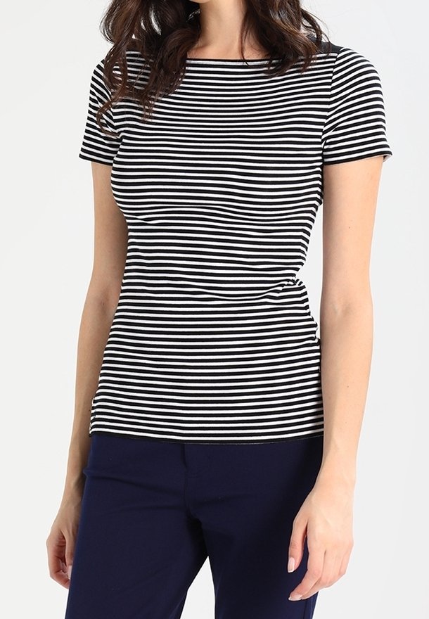 Haut à manches courtes noir et blanc rayé avec un col rond ; design ajusté en tissu doux et extensible. Accompagné de pantalons navy.