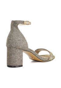 Open-toe heeled sandal in shimmering gold material with a thick block heel, ankle strap, and smooth inner lining.