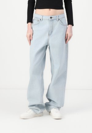 Lyseblå denim vide bukser med høy livhøyde, med frontlommer, glidelås og kontraststing. Kombinert med hvite sneakers.