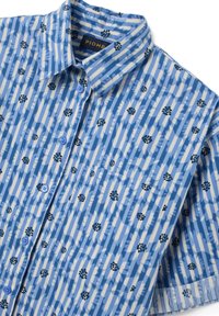 Camicia a maniche corte con bottoni di colore blu, caratterizzata da motivi floreali astratti in bianco e nero, con colletto, taschino frontale e bottoni blu chiaro.