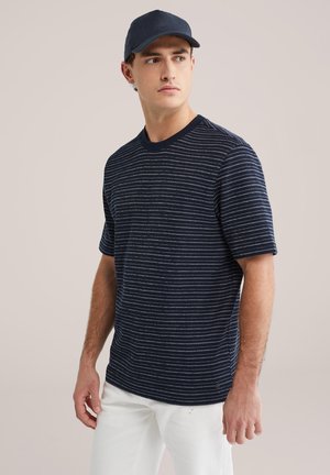 Marineblauw gestreept gebreid T-shirt met korte mouwen en een ronde hals. Voorzien van witte horizontale strepen en een klein logo aan de onderzoom.