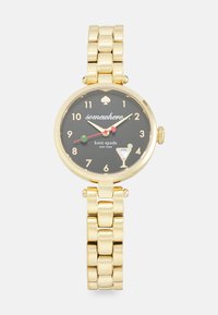 Gold-tone watch with a black dial, featuring a spade logo, colorful hour markers, and a cocktail glass motif. Chunky link bracelet design.