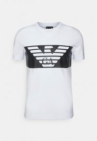 White short-sleeve t-shirt with black rectangular chest logo featuring stylized eagle wings and the letters "GA" in the center.