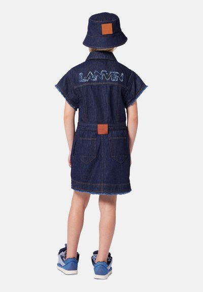 Jeansjurk in diepblauw met korte mouwen, franjes aan de onderkant en "LANVIN" geborduurd op de achterkant. Gecombineerd met een bijpassende denim bucket hat.