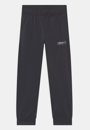 Czarne spodnie dresowe Adidas Adventure z elastycznym pasem, kieszeniami na zamek i żebrowanymi ściągaczami, pokazane rozłożone na białym tle.