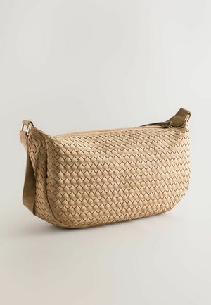Woven beige bag with a curved shape, featuring a zip closure, adjustable strap, and a textured surface with a basketweave pattern.