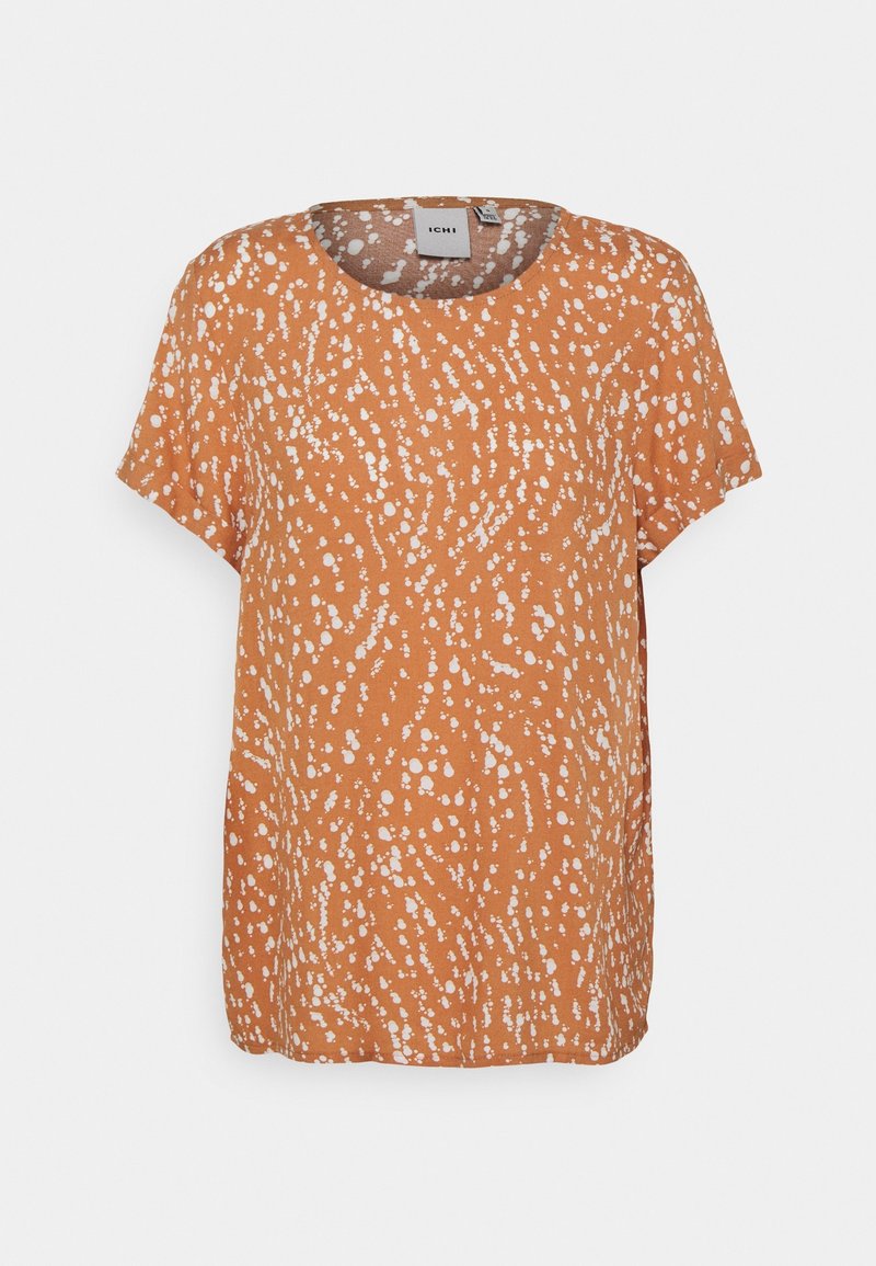 Pomarańczowa bluzka z krótkim rękawem w biały cętkowany wzór, okrągły dekolt, luźny krój i miękka faktura materiału. Metka widoczna wewnątrz.