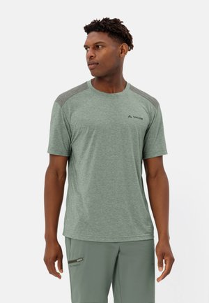Camiseta deportiva verde de manga corta, con tejido texturizado, acentos en los hombros en gris y detalle de logo en el pecho, combinada con pantalones a juego.