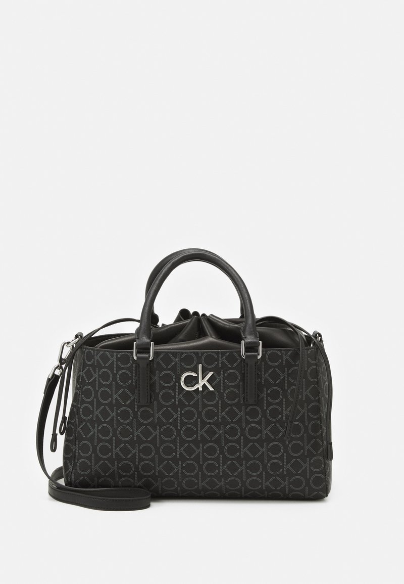 Černá kabelka s texturovaným vzorem loga, dvojitými uchy, odnímatelným ramenním popruhem a stříbrnými kovovými doplňky. Obdélníkový tvar.