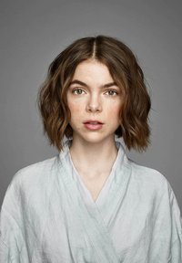 Linnen wikkel in een lichte mintgroene kleur, met een v-hals kraag en een gestructureerd oppervlak. Het onderwerp heeft schouderlang, golvend bruin haar.