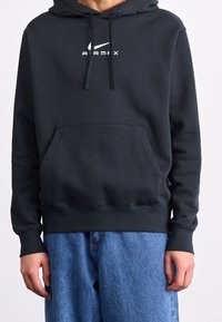 Mörkgrå hoodie med en framficka, dragsko och vit "AIRMAX"-logotyp. Ribbad ärmslut och nederkant, tillverkad av mjukt material. Avslappnad passform.