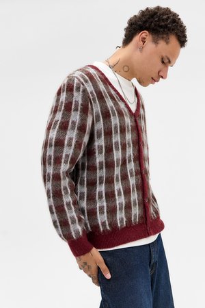 Cardigan avec un décolleté en V profond, présentant un motif à carreaux en bordeaux et gris, fabriqué en matériau duveteux. Manches et ourlet côtelés.