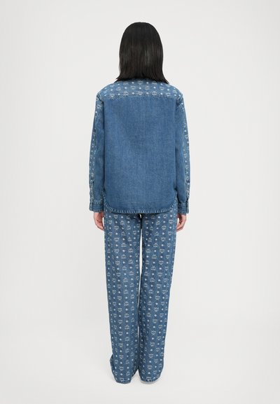 Jachetă din denim cu mâneci cu un model în albastru deschis; asortată cu pantaloni ușori din albastru deschis cu un model floral repetat; croi lejer.