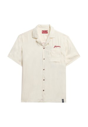 Korte mouw beige shirt gemaakt van zachte stof, voorzien van een borstzak en rode geborduurde tekst "Japan," met knoopsluiting en afgeronde zoom.