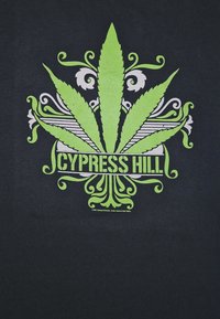 Svart T-skjorte med et sentralt motiv av et stort grønt cannabisblad med utsmykkede hvite detaljer og teksten "Cypress Hill" under.