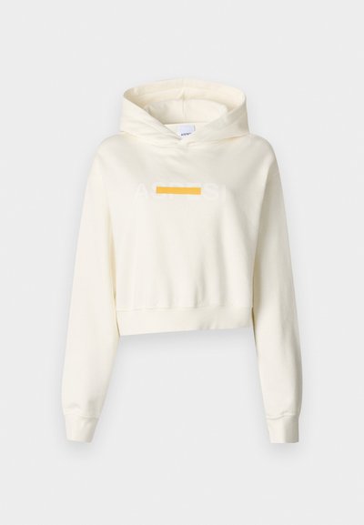 Hoodie blanc court avec une texture douce, présentant un graphique à l'avant en orange et gris clair. Comprend une capuche et des manches longues.