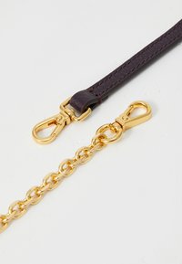 Leather strap in dark burgundy with gold hardware, featuring a lobster clasp and a chain link design adjacent. Smooth texture, sleek appearance.