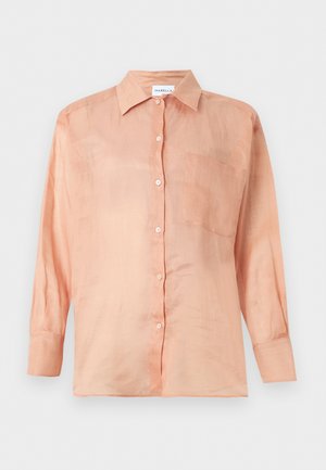 Lyse ferskenfarvet langærmet skjorte med krave og enkelt brystlomme, vist på en ensfarvet hvid baggrund.