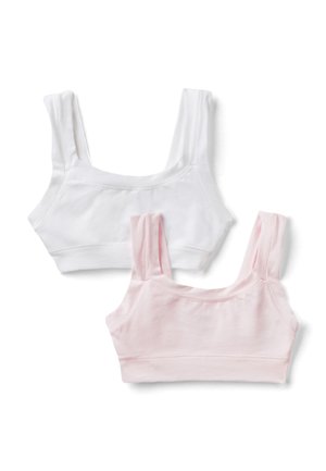 Due top crop senza maniche in cotone, uno bianco e uno rosa chiaro, distesi su uno sfondo bianco.